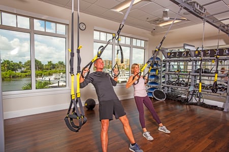 man and woman using TRX by marina